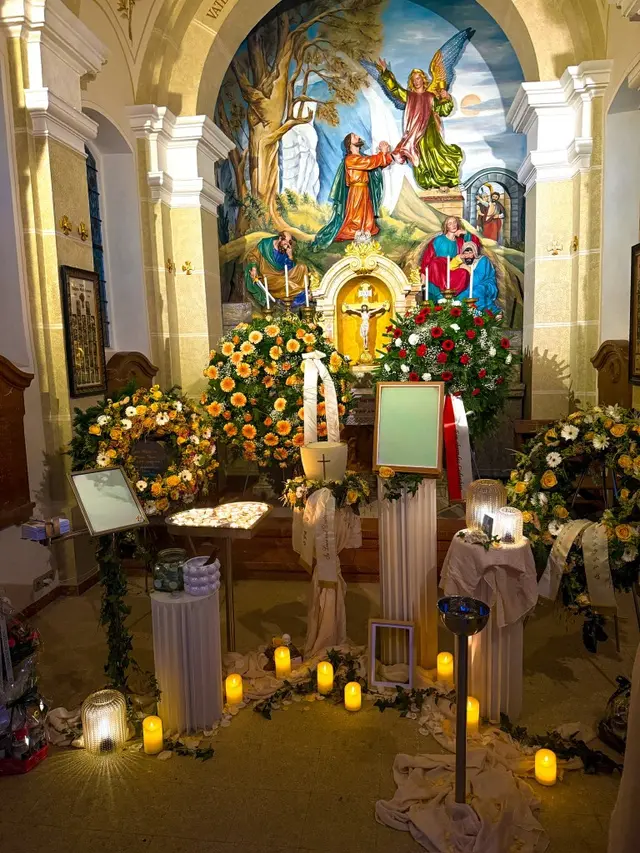 Würdevolle Aufbahrung mit Blumen und Kerzen in einer Kirche